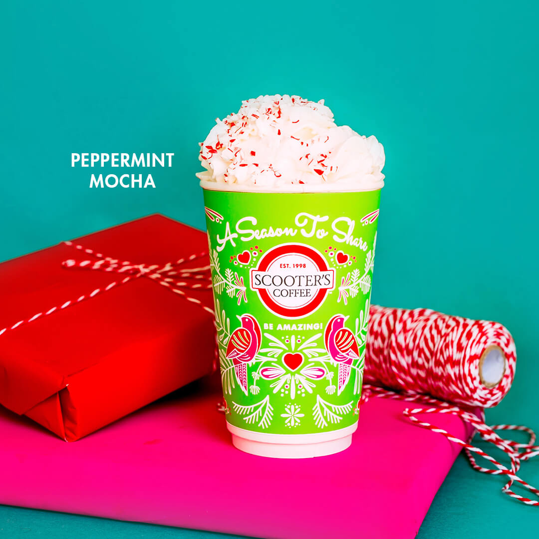 Green coffee cup with whipped cream topped with peppermint chips