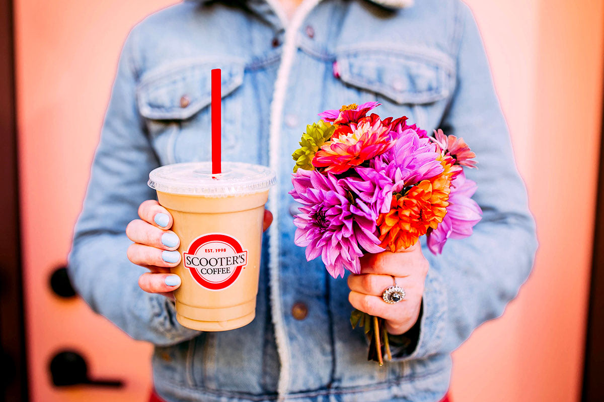 Woman holding blended coffee and flowers
